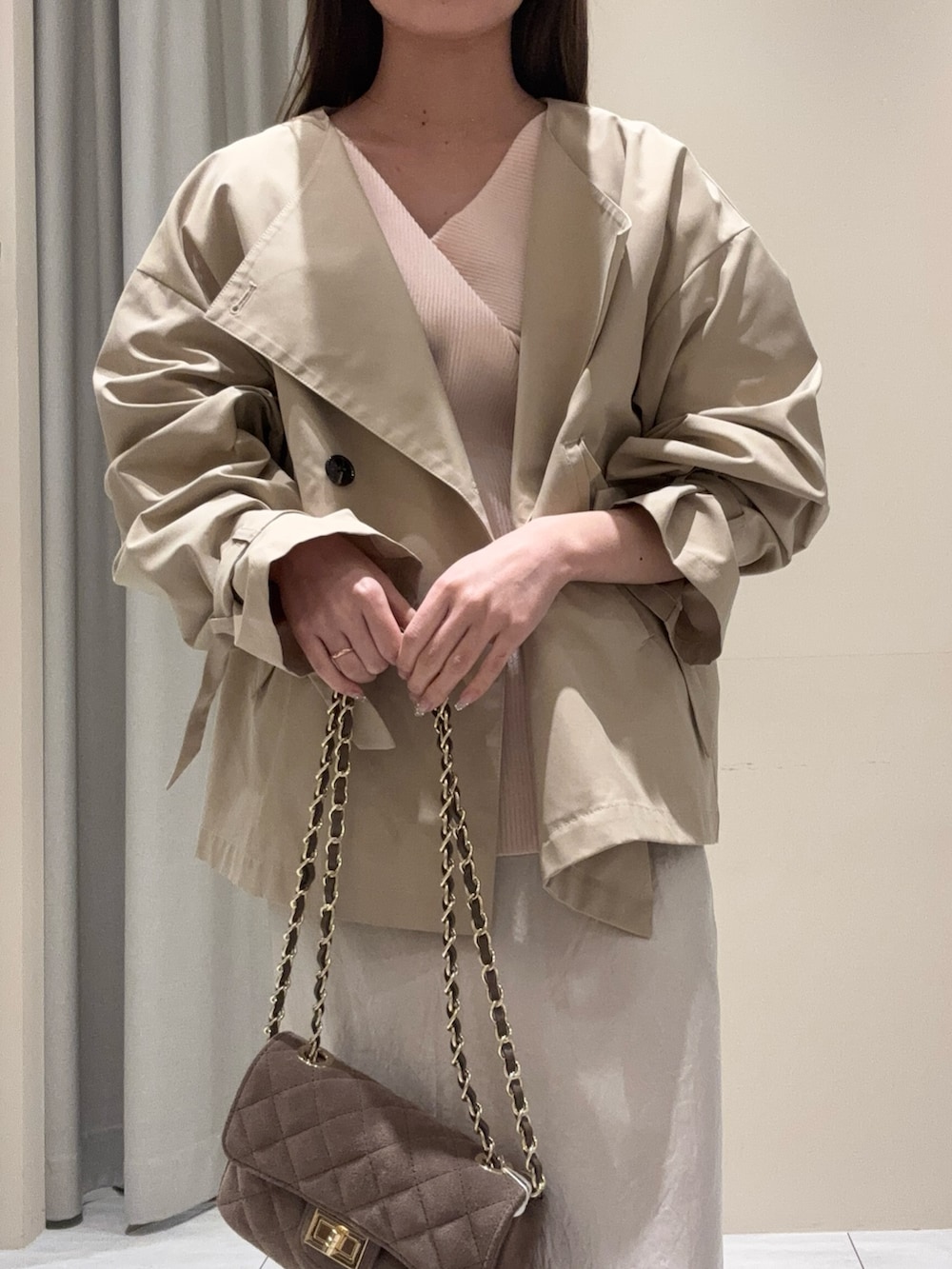 ベージュ系のトレンチコート、ピンク系のニット/セーター、ホワイト系のスカートを着用したレディースの春コーディネートの4枚目の写真