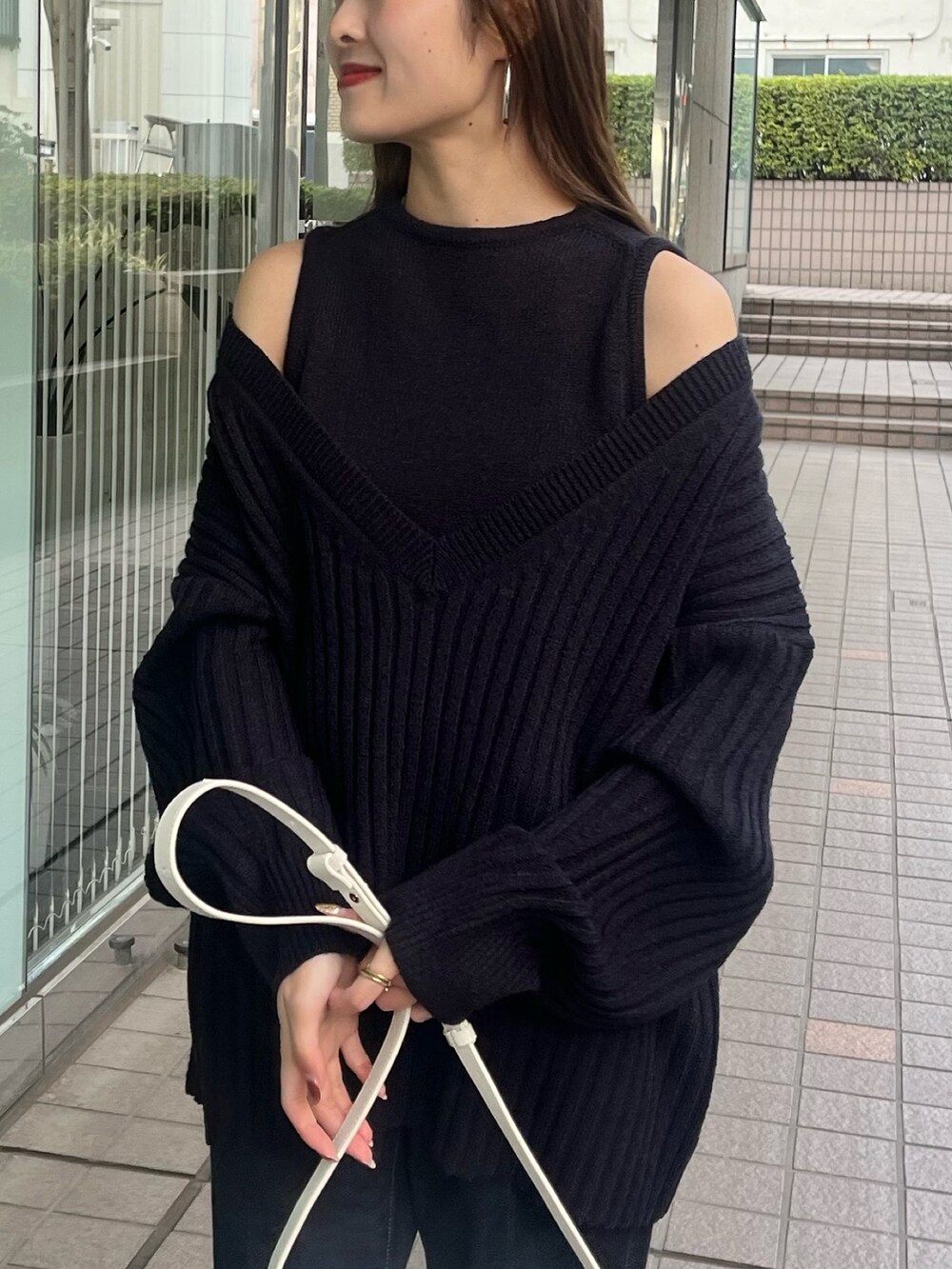 ホワイト系のニット/セーター、ブルー系のデニムパンツ、ホワイト系のショルダーバッグを着用したレディースの春コーディネートの4枚目の写真