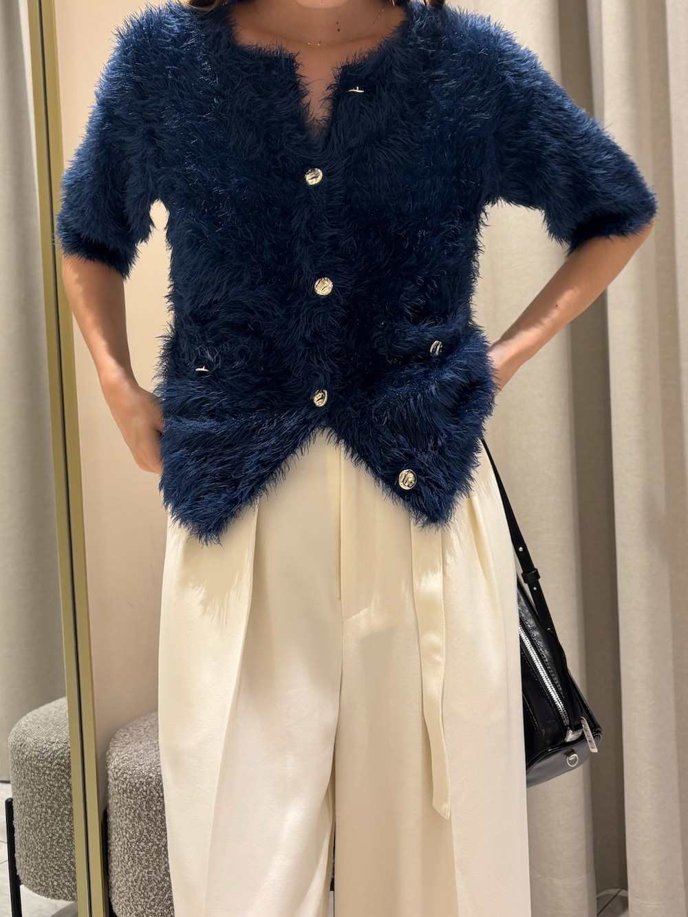 ブルー系のカーディガン/ボレロ、ホワイト系のスラックスを着用したレディースの秋コーディネートの4枚目の写真