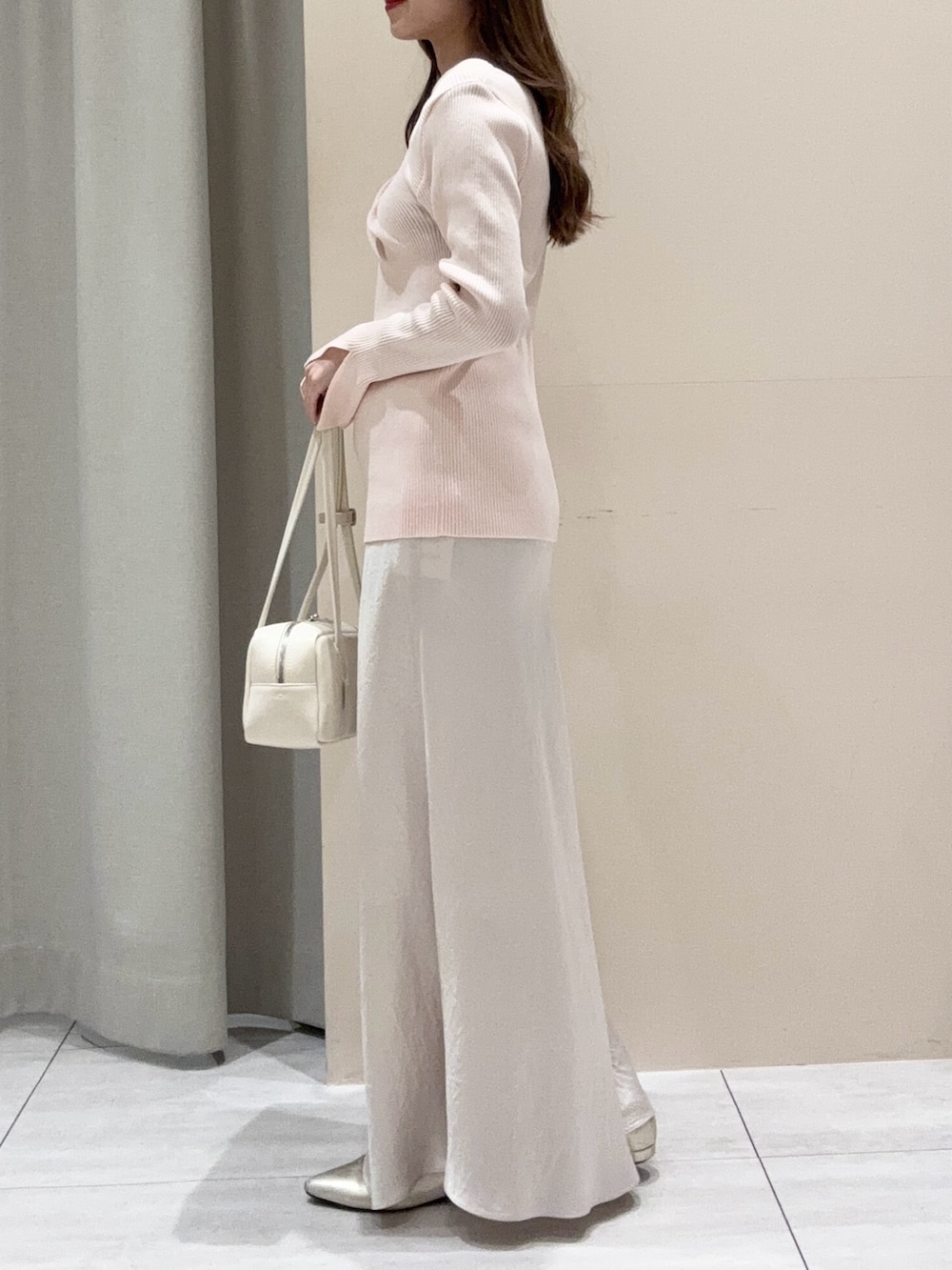 ピンク系のニット/セーター、ホワイト系のスカートを着用したレディースの春コーディネートの2枚目の写真