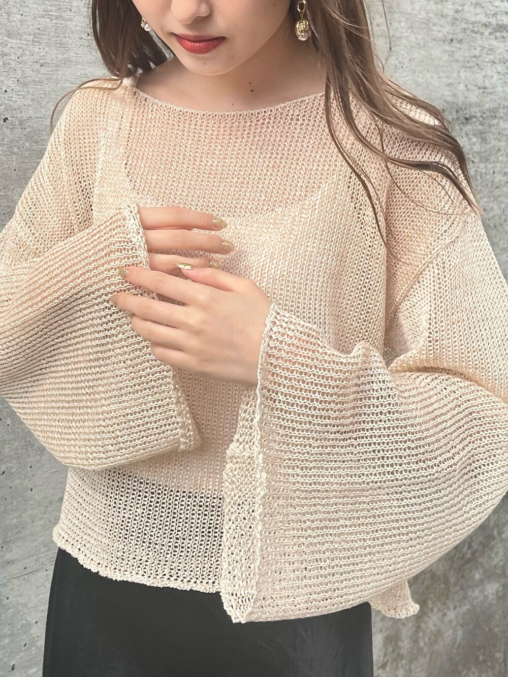 ベージュ系のニット/セーター、ブラック系のスカート、ブラック系のサンダルを着用したレディースの春コーディネートの3枚目の写真