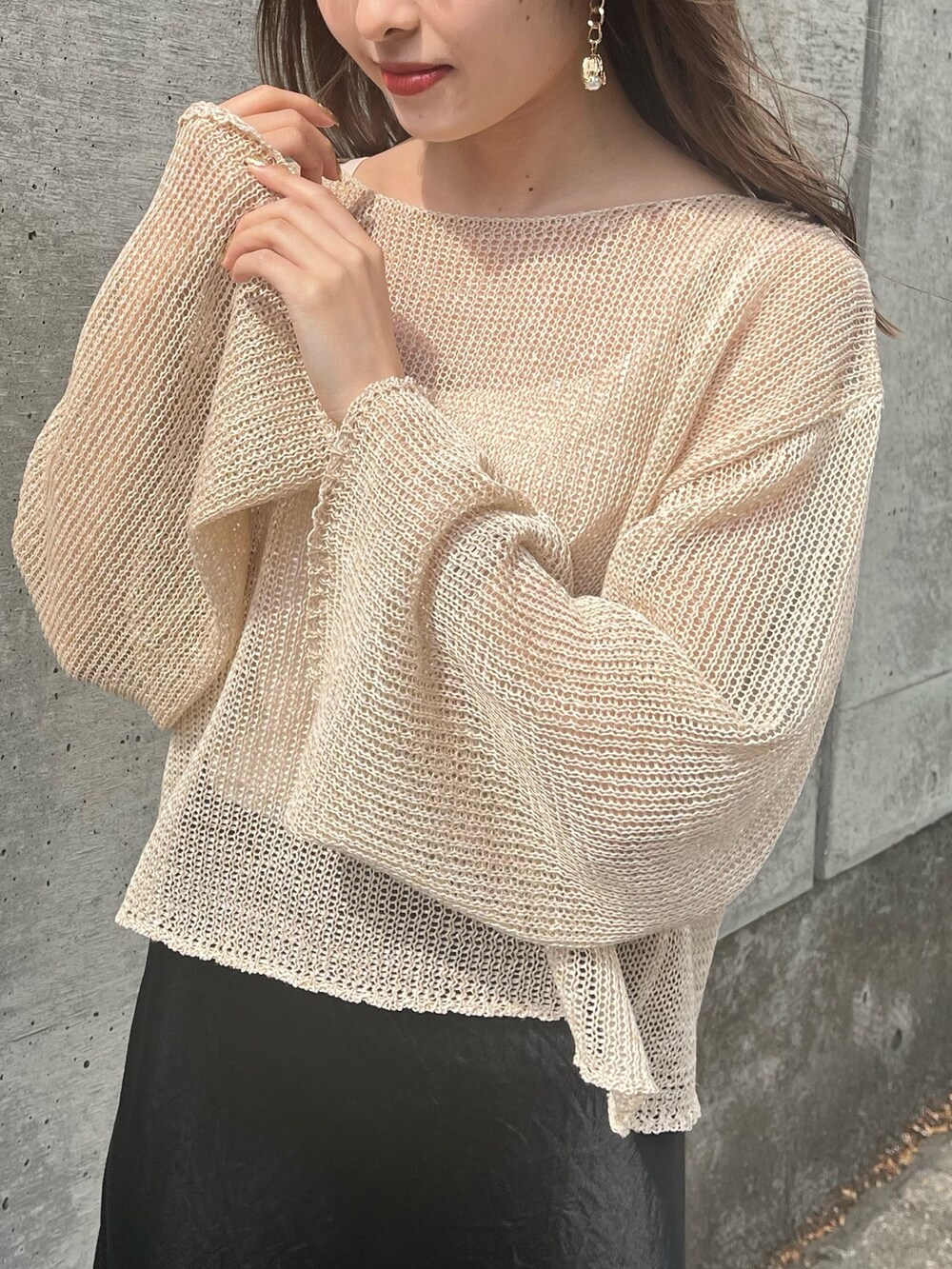 ベージュ系のニット/セーター、ブラック系のスカート、ブラック系のサンダルを着用したレディースの春コーディネートの4枚目の写真