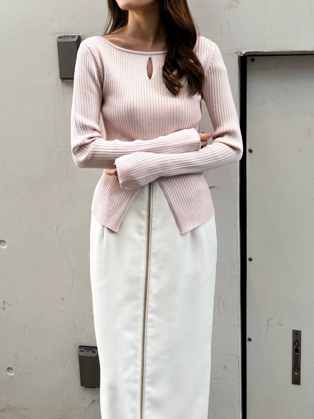 ピンク系のニット/セーター、ホワイト系のスカート、ホワイト系のブーツを着用したレディースの冬コーディネートの4枚目の写真