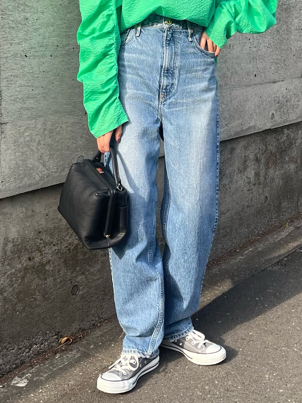 グリーン系のシャツ/ブラウス、グレー系のスニーカー、ブルー系のデニムパンツを着用したレディースの春コーディネートの6枚目の写真