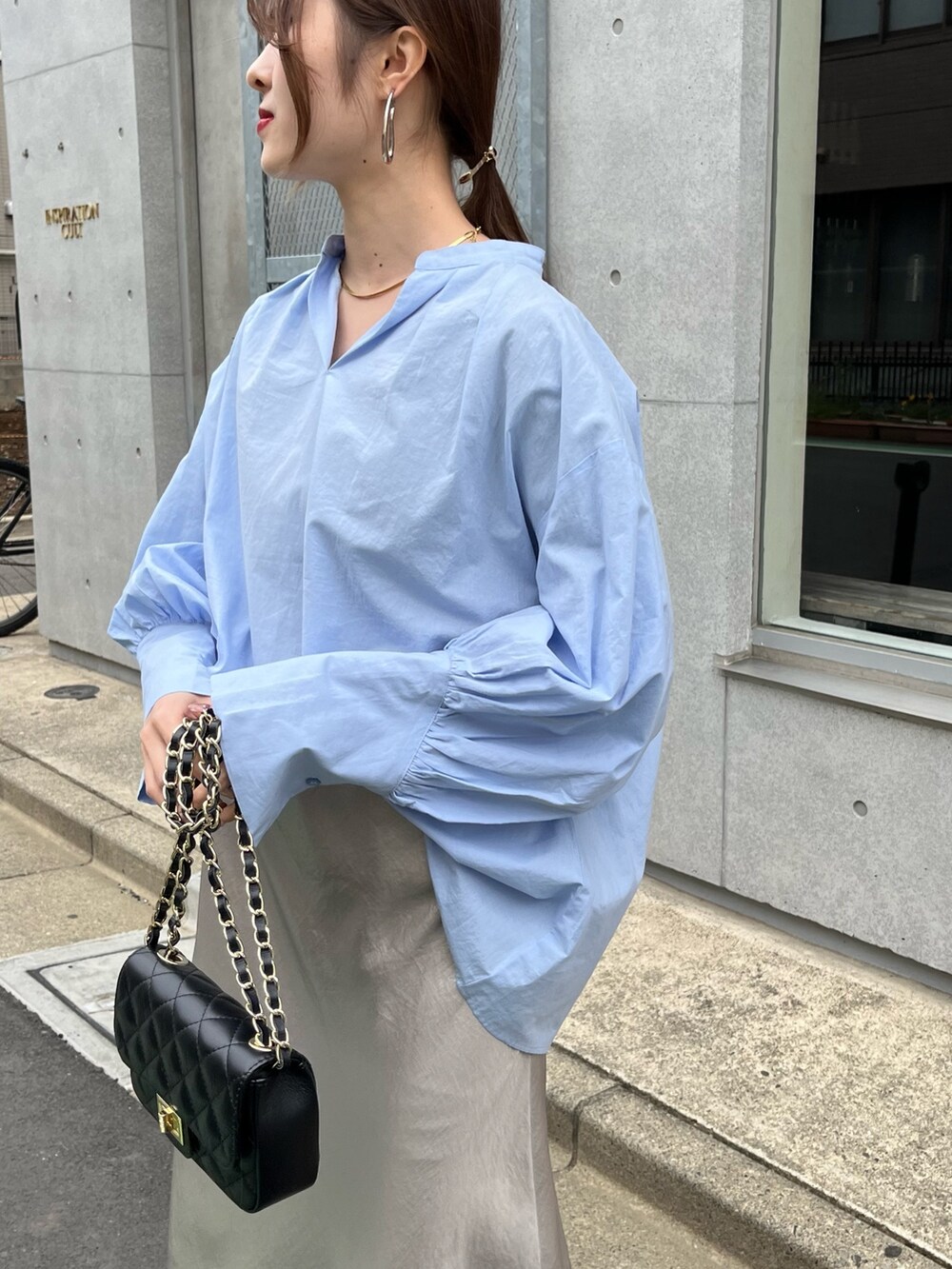 ブルー系のシャツ/ブラウス、ブラック系のショルダーバッグ、ベージュ系のスカートを着用したレディースの春コーディネートの10枚目の写真