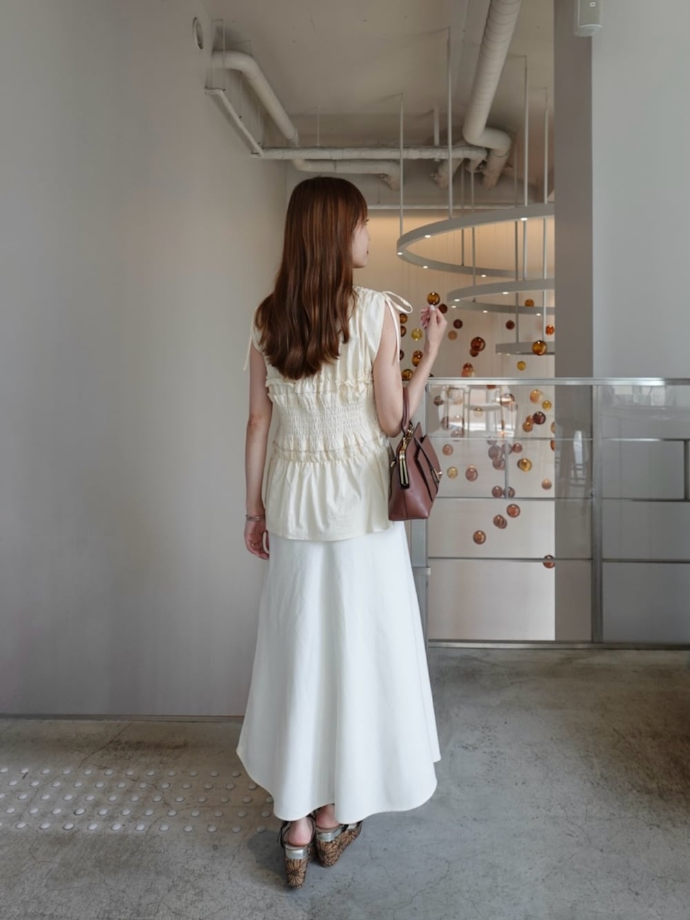 ブラック系のシャツ/ブラウス、ベージュ系のスカートを着用したレディースの夏コーディネートの4枚目の写真