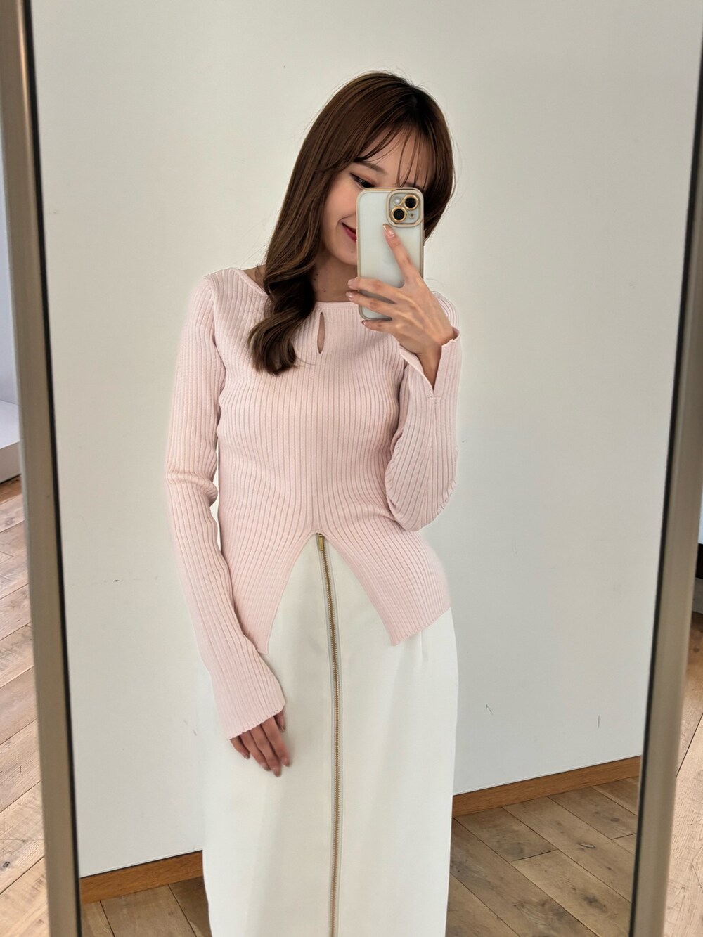 ピンク系のニット/セーター、ホワイト系のスカート、ホワイト系のブーツを着用したレディースの冬コーディネートの6枚目の写真