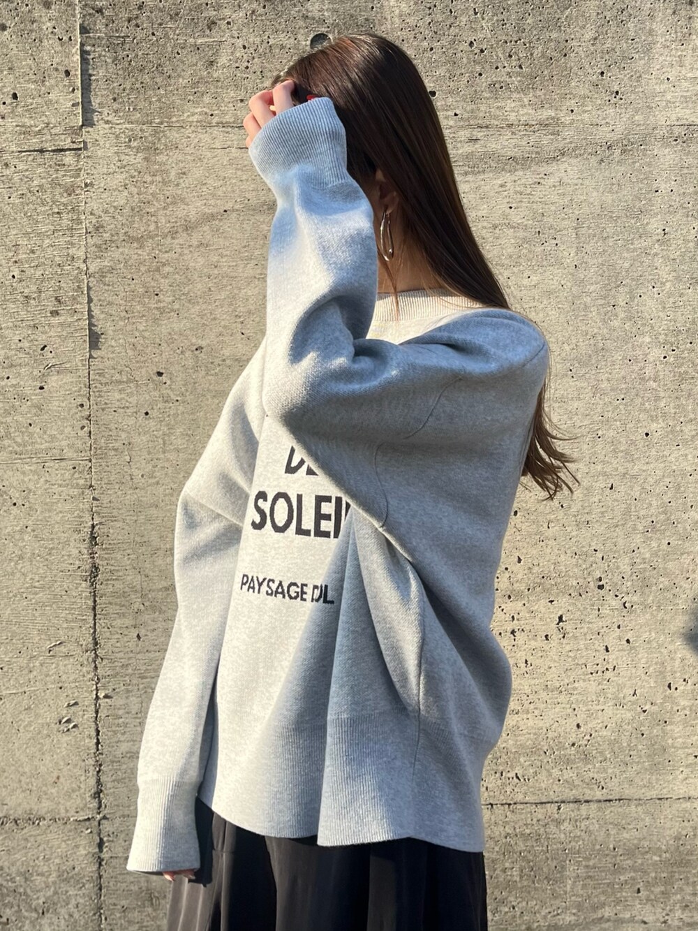 グレー系のニット/セーター、ブルー系のワンピース、ブラック系のショルダーバッグを着用したレディースの冬コーディネートの5枚目の写真