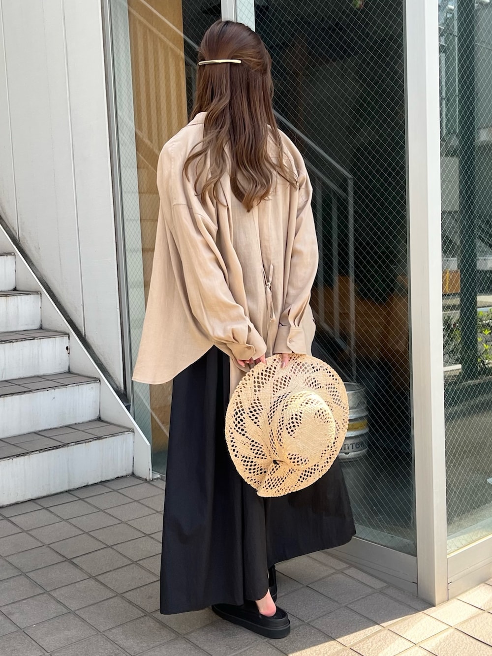 ブラック系のワンピース、ベージュ系のシャツ/ブラウス、ブラック系のサンダルを着用したレディースの春コーディネートの3枚目の写真