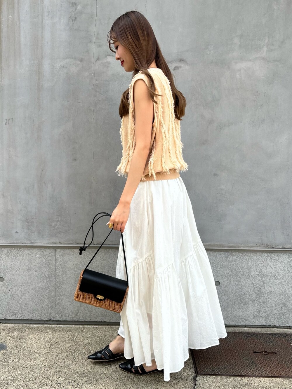 ベージュ系のニット/セーター、ホワイト系のスカート、ブラック系のショルダーバッグを着用したレディースの春コーディネートの3枚目の写真