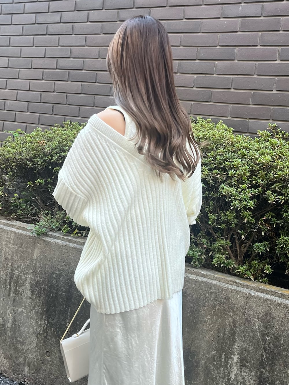 ホワイト系のニット/セーター、ホワイト系のスカート、ホワイト系のパンプスを着用したレディースの冬コーディネートの3枚目の写真