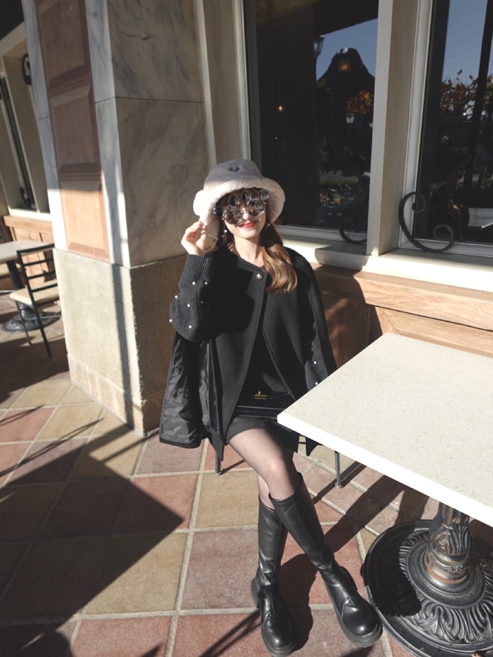 ベージュ系のポンチョ、グレー系のニット/セーターを着用したレディースの冬コーディネートの2枚目の写真