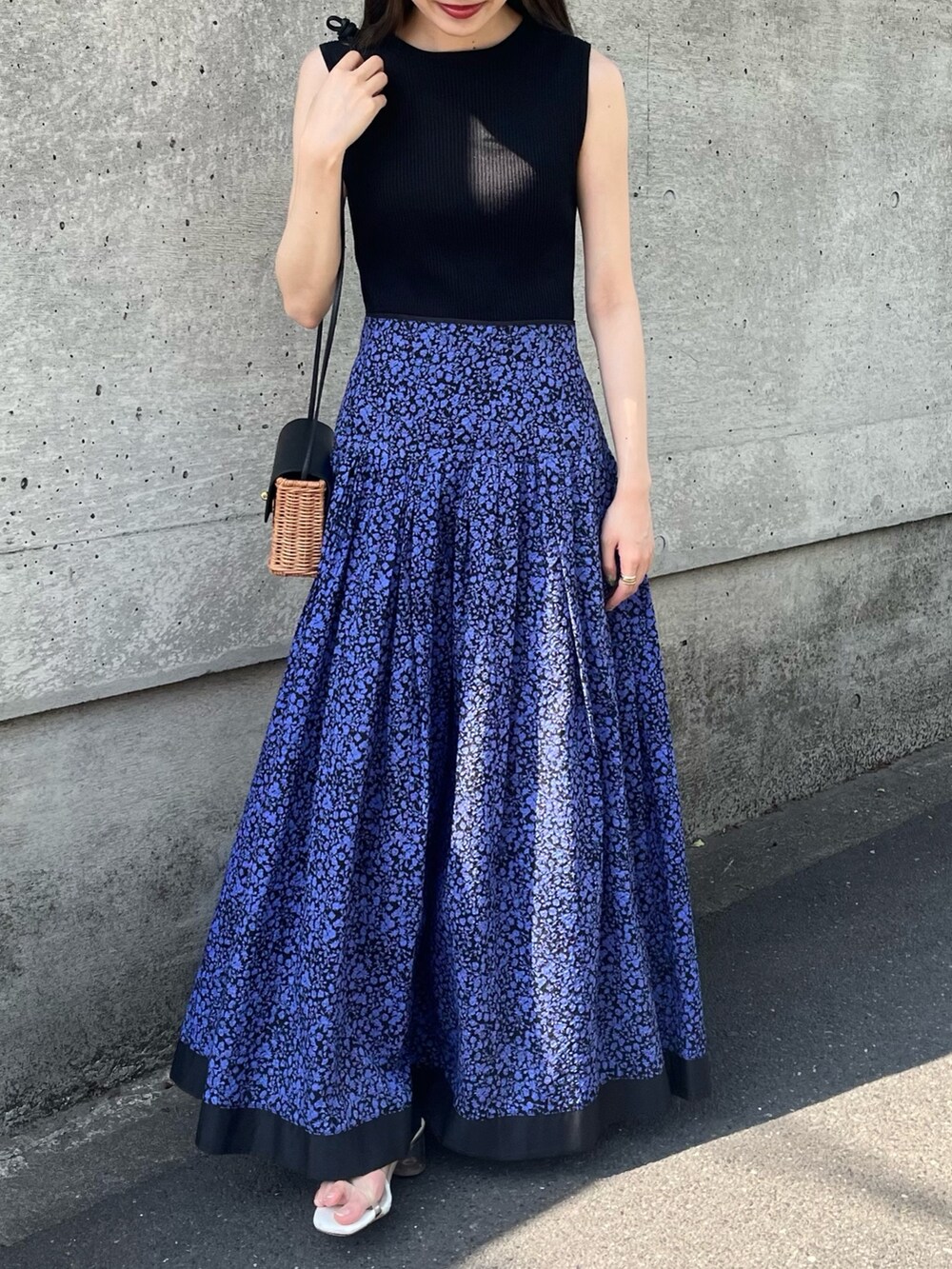 ブルー系のスカート、ブラック系のニット/セーター、ブラック系のショルダーバッグを着用したレディースの春コーディネートの2枚目の写真