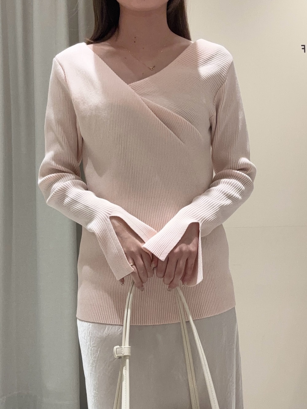 ピンク系のニット/セーター、ホワイト系のスカートを着用したレディースの春コーディネートの4枚目の写真