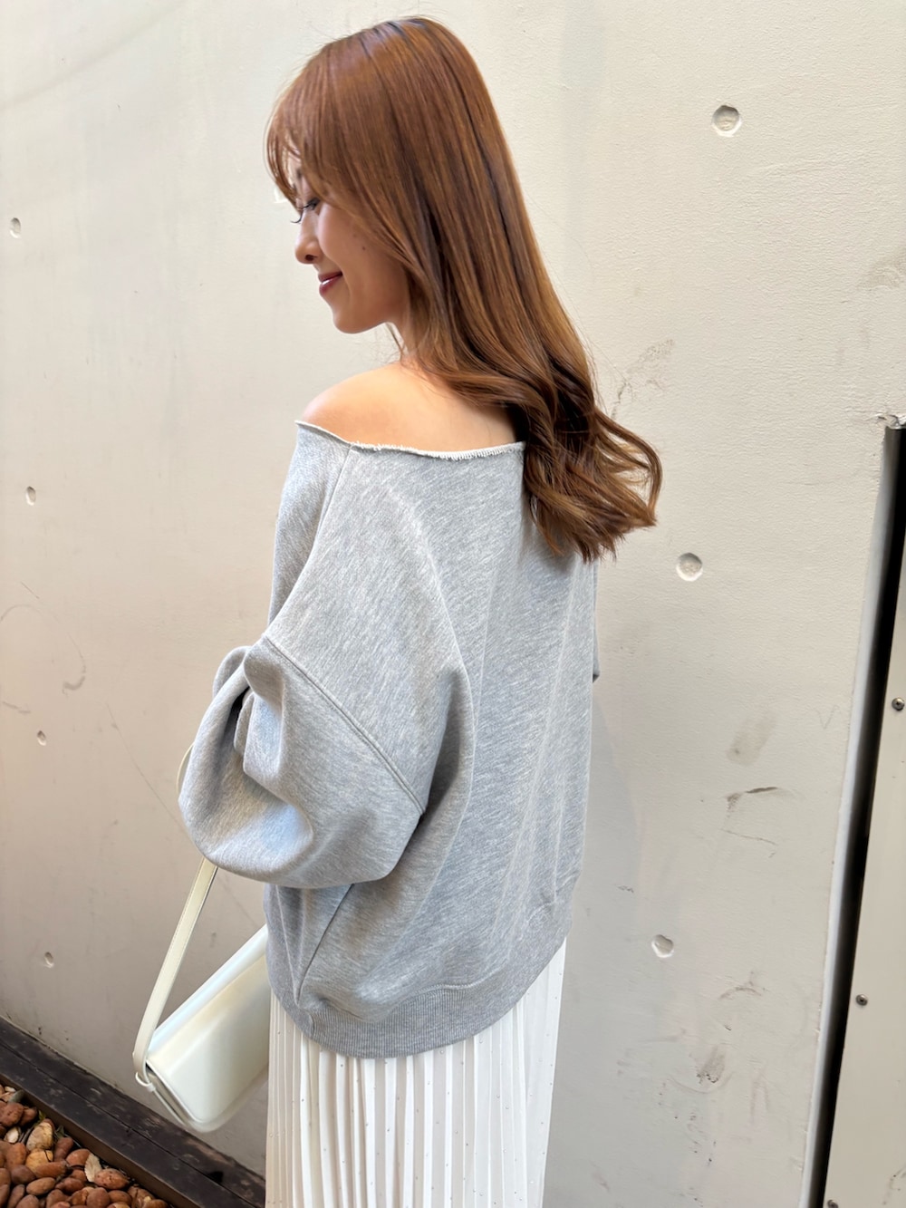 グレー系のTシャツ/カットソー、ホワイト系のスカート、シルバー系のシューズを着用したレディースの冬コーディネートの4枚目の写真