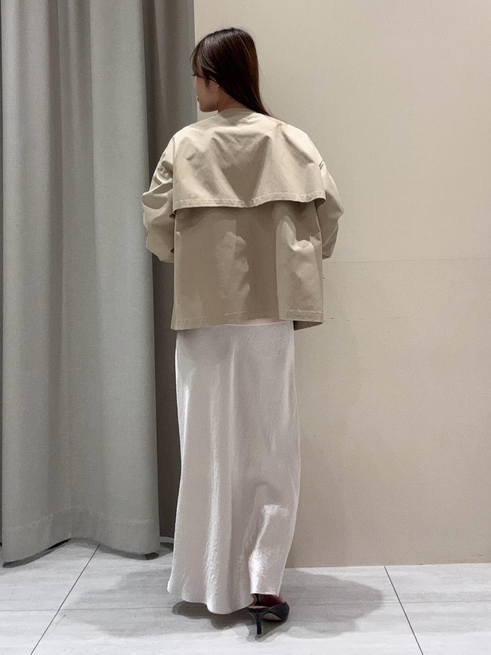 ベージュ系のトレンチコート、ピンク系のニット/セーター、ホワイト系のスカートを着用したレディースの春コーディネートの3枚目の写真