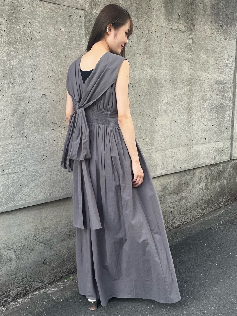 グレー系のワンピース、ブラック系のタンクトップを着用したレディースの春コーディネートの2枚目の写真