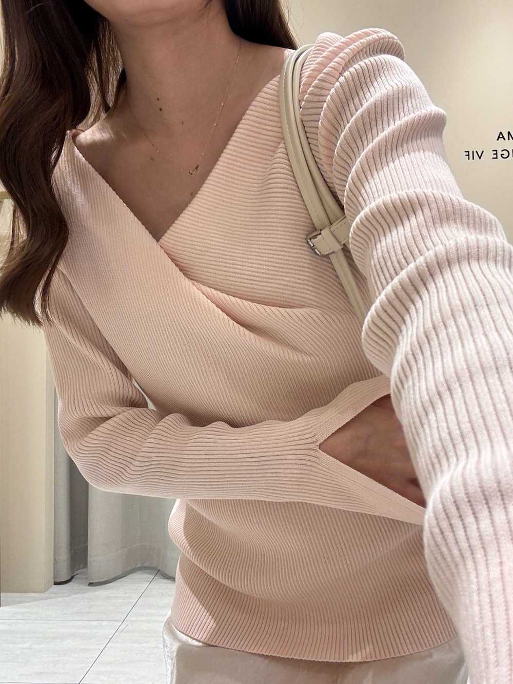 ピンク系のニット/セーター、ホワイト系のスカートを着用したレディースの春コーディネートの6枚目の写真