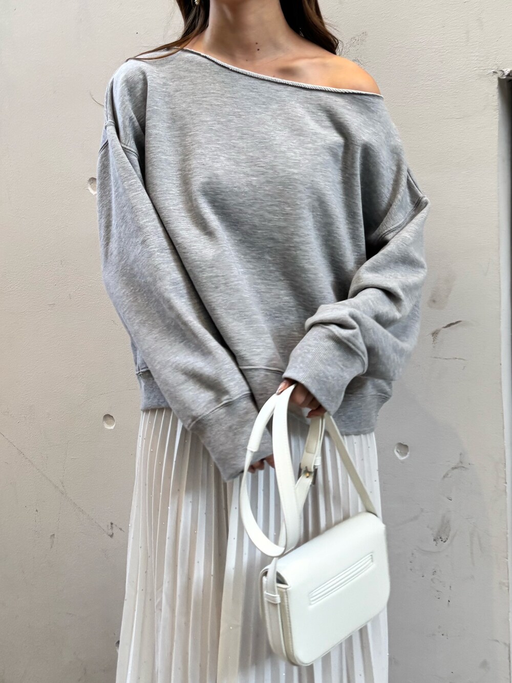 グレー系のTシャツ/カットソー、ホワイト系のスカート、シルバー系のシューズを着用したレディースの冬コーディネートの2枚目の写真