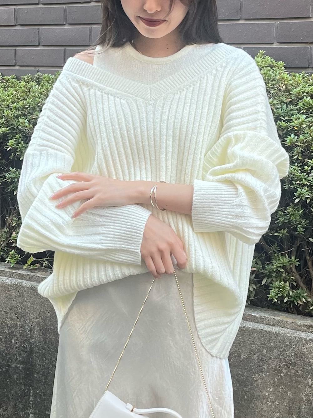 ホワイト系のニット/セーター、ホワイト系のスカート、ホワイト系のパンプスを着用したレディースの冬コーディネートの4枚目の写真