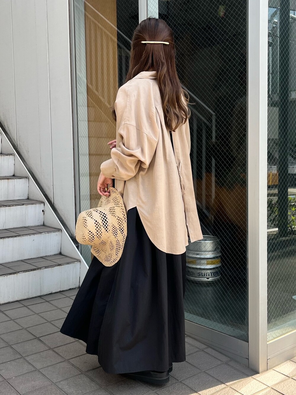 ブラック系のワンピース、ベージュ系のシャツ/ブラウス、ブラック系のサンダルを着用したレディースの春コーディネートの2枚目の写真