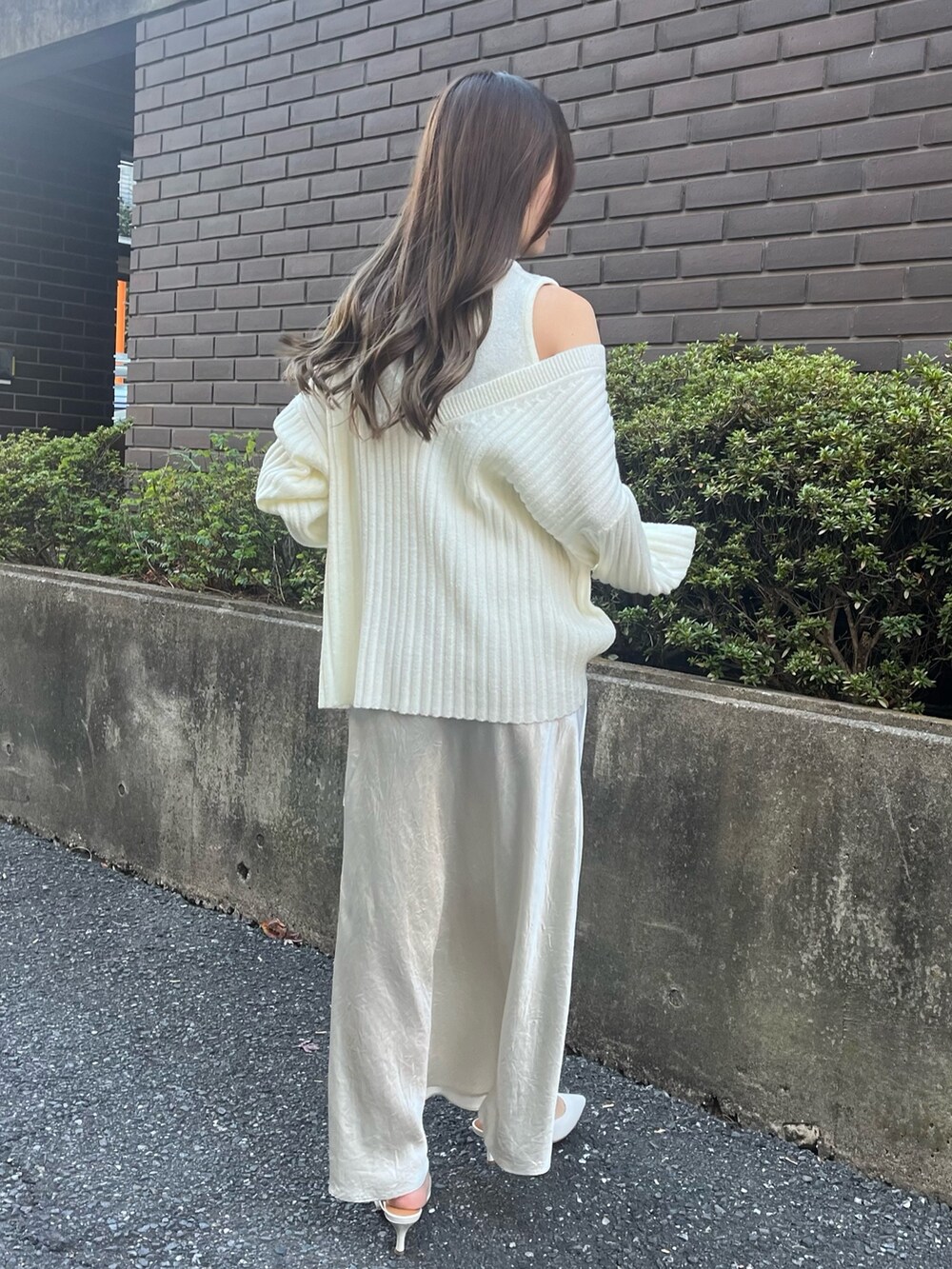 ホワイト系のニット/セーター、ホワイト系のスカート、ホワイト系のパンプスを着用したレディースの冬コーディネートの2枚目の写真