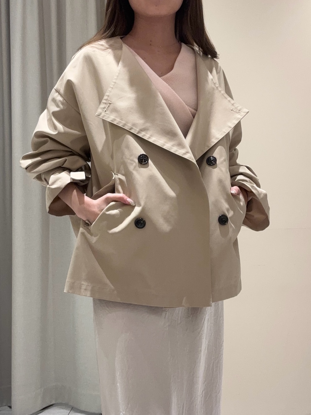 ベージュ系のトレンチコート、ピンク系のニット/セーター、ホワイト系のスカートを着用したレディースの春コーディネートの5枚目の写真