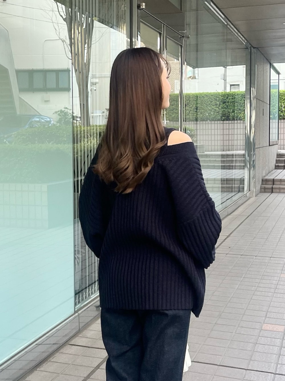 ホワイト系のニット/セーター、ブルー系のデニムパンツ、ホワイト系のショルダーバッグを着用したレディースの春コーディネートの6枚目の写真