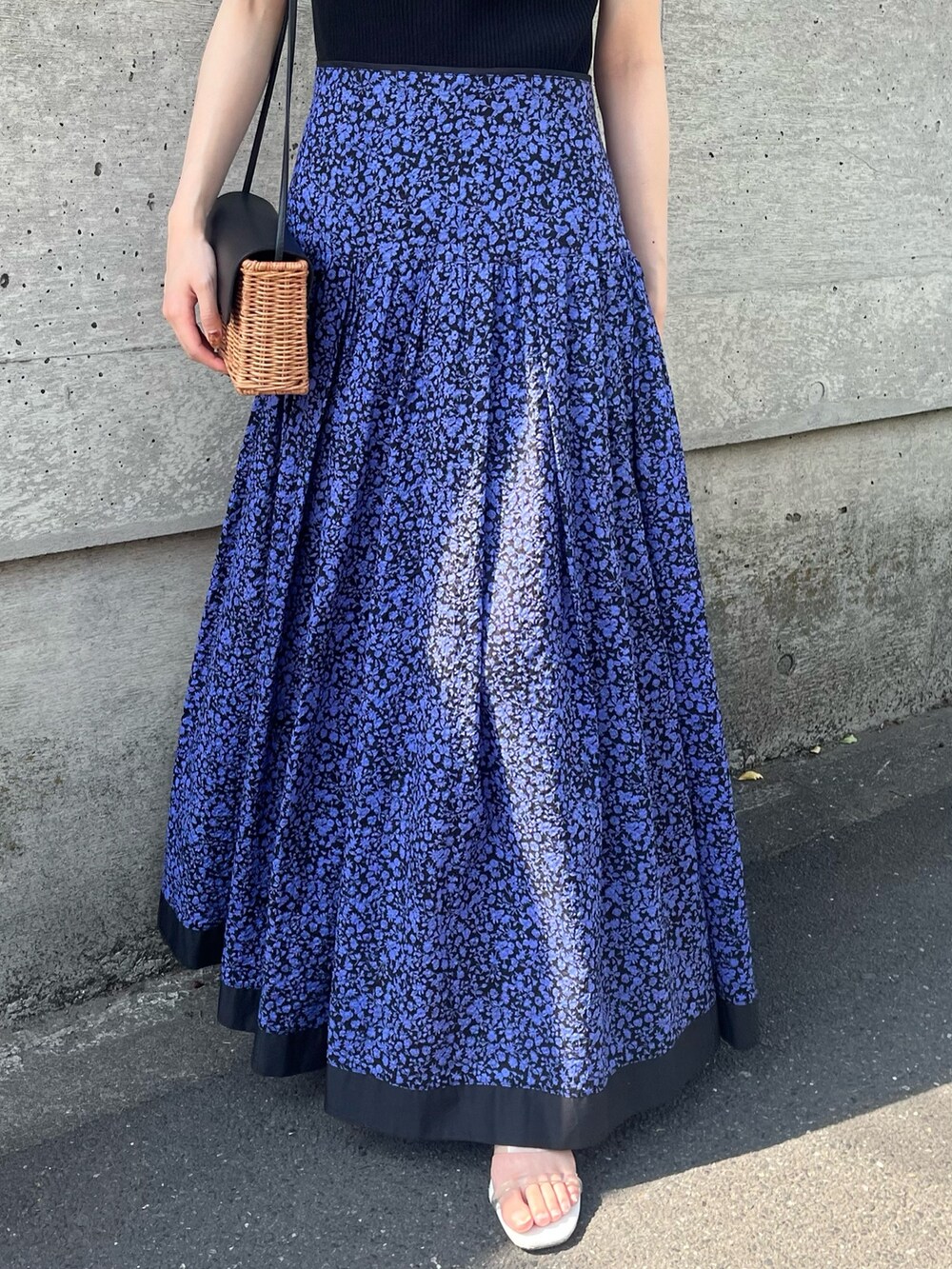 ブルー系のスカート、ブラック系のニット/セーター、ブラック系のショルダーバッグを着用したレディースの春コーディネートの3枚目の写真