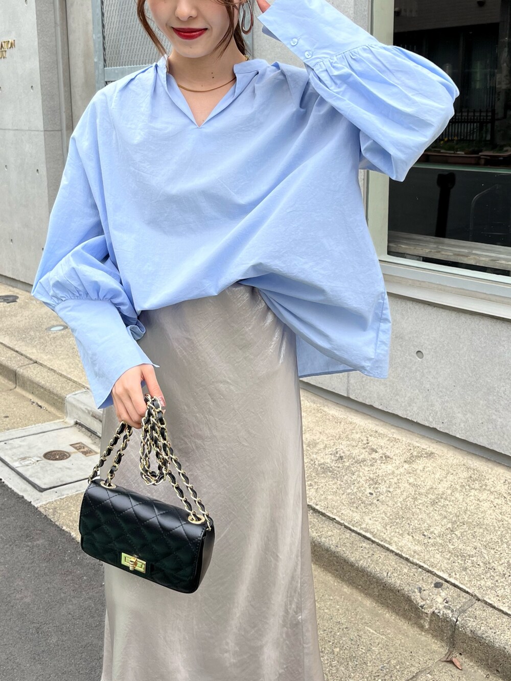 ブルー系のシャツ/ブラウス、ブラック系のショルダーバッグ、ベージュ系のスカートを着用したレディースの春コーディネートの6枚目の写真
