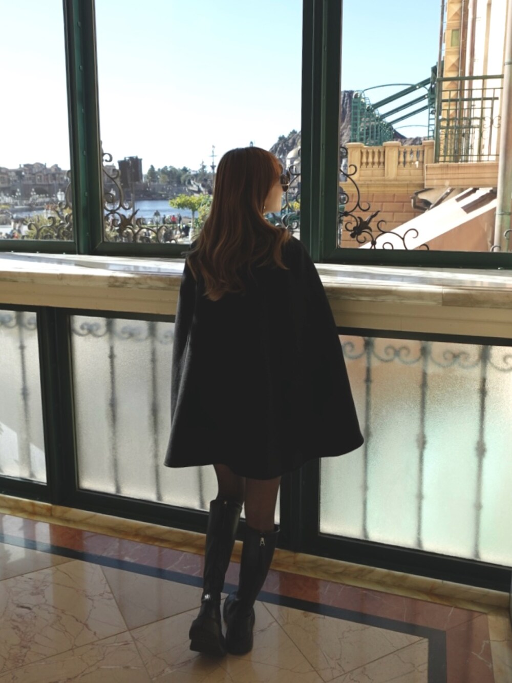 ベージュ系のポンチョ、グレー系のニット/セーターを着用したレディースの冬コーディネートの3枚目の写真