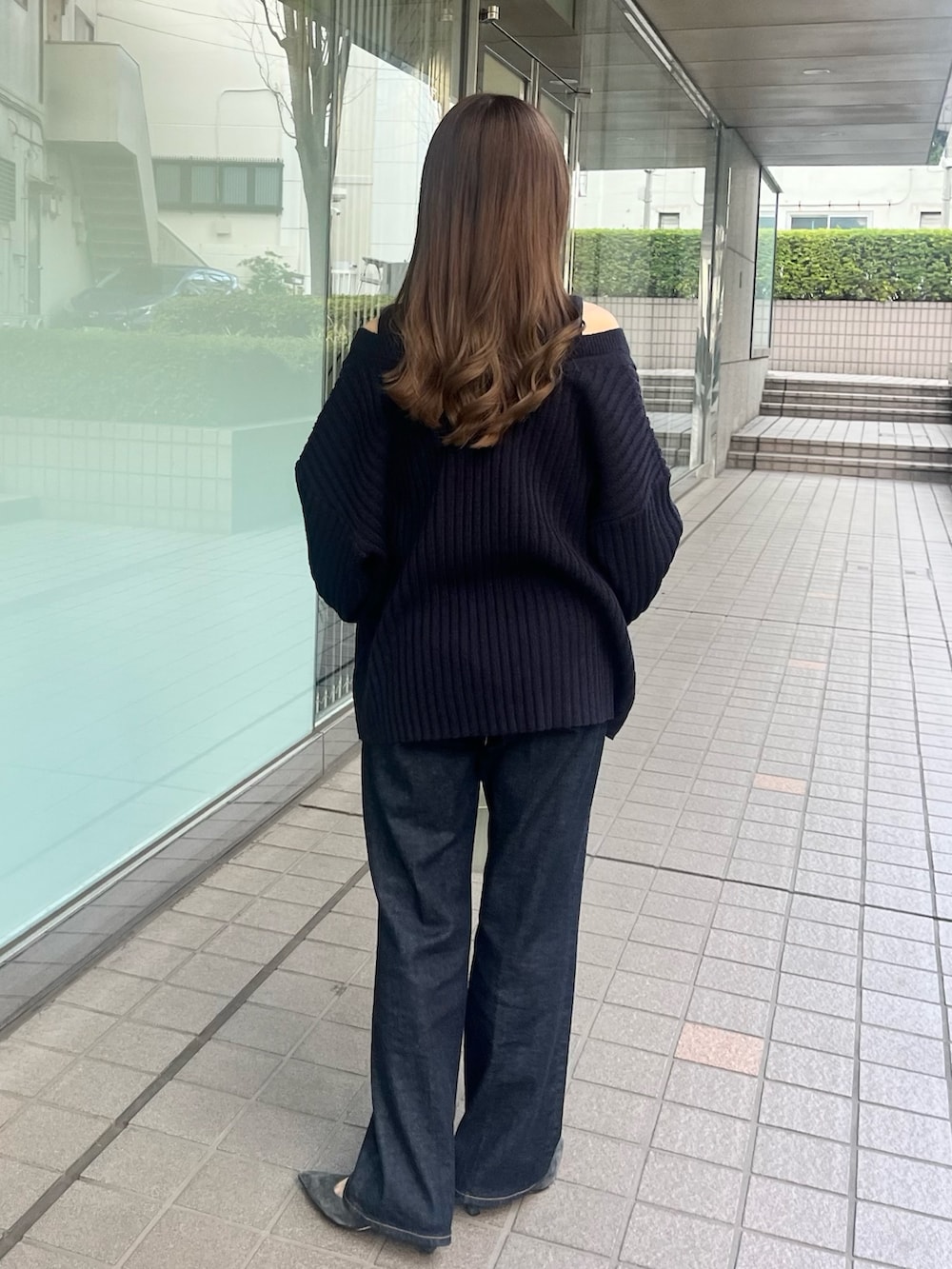 ホワイト系のニット/セーター、ブルー系のデニムパンツ、ホワイト系のショルダーバッグを着用したレディースの春コーディネートの3枚目の写真