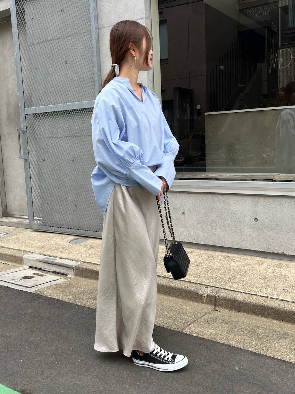 ブルー系のシャツ/ブラウス、ブラック系のショルダーバッグ、ベージュ系のスカートを着用したレディースの春コーディネートの2枚目の写真