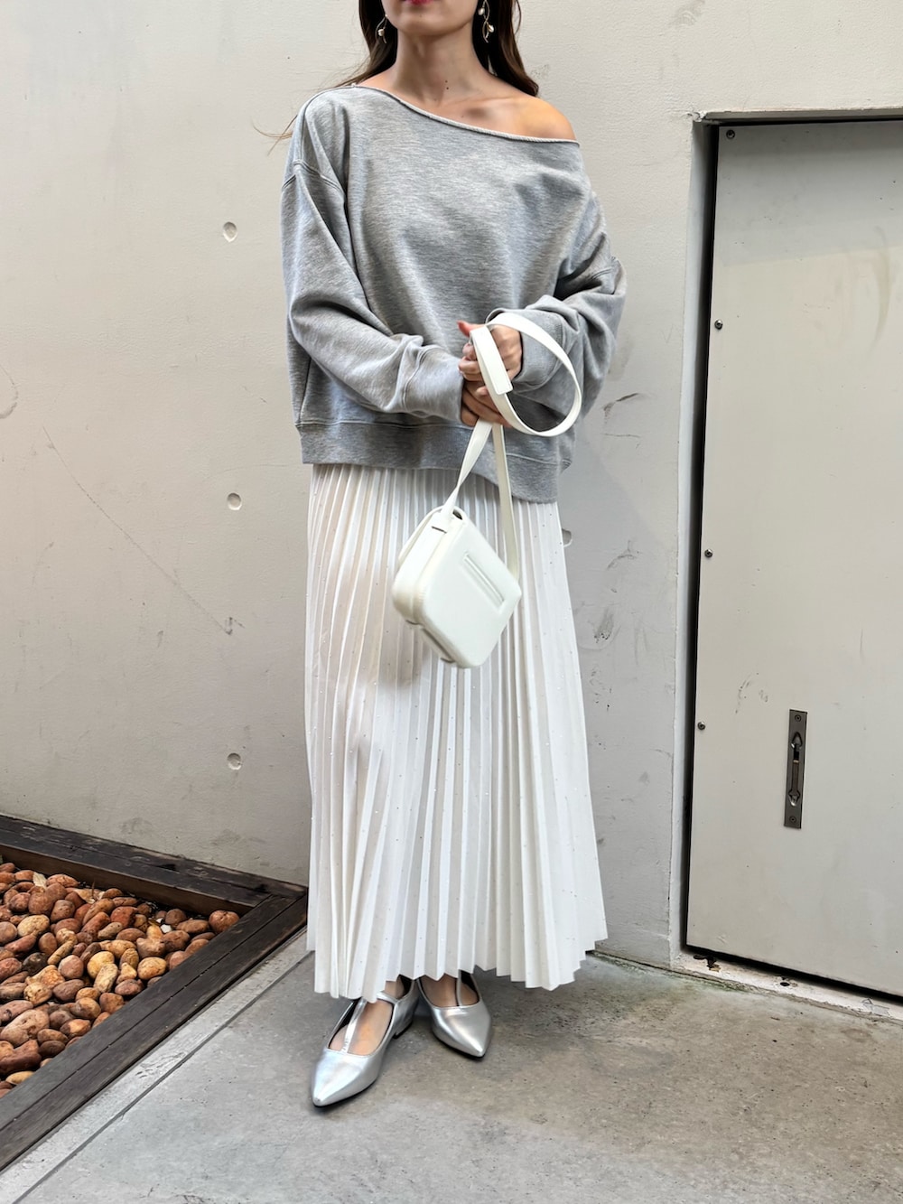 グレー系のTシャツ/カットソー、ホワイト系のスカート、シルバー系のシューズを着用したレディースの冬コーディネートの5枚目の写真