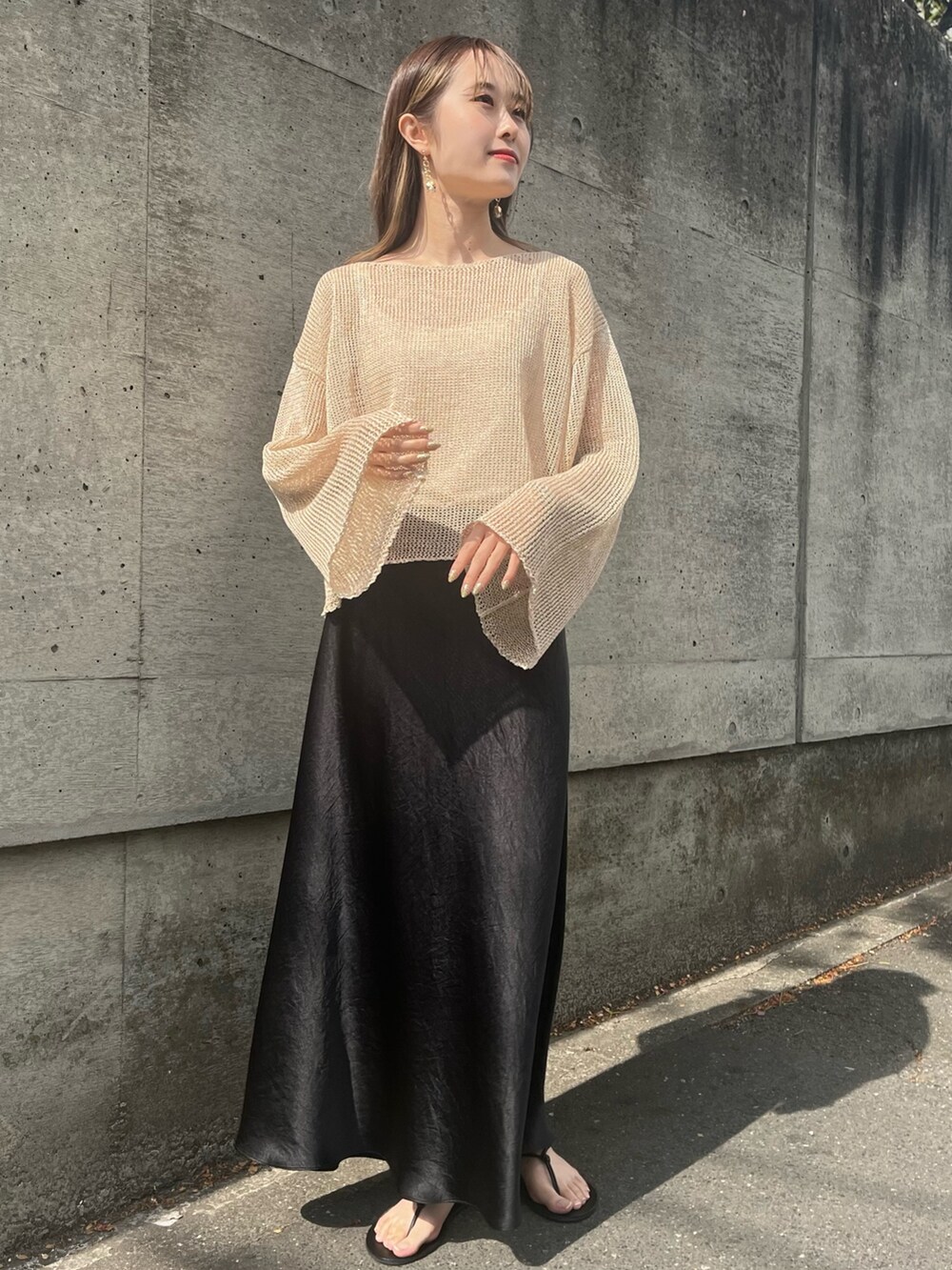 ベージュ系のニット/セーター、ブラック系のスカート、ブラック系のサンダルを着用したレディースの春コーディネートの2枚目の写真