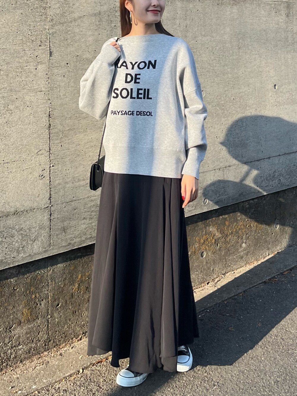 グレー系のニット/セーター、ブルー系のワンピース、ブラック系のショルダーバッグを着用したレディースの冬コーディネートの4枚目の写真