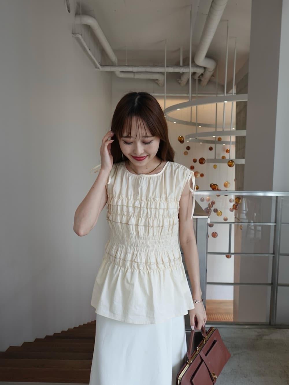 ブラック系のシャツ/ブラウス、ベージュ系のスカートを着用したレディースの夏コーディネートの5枚目の写真