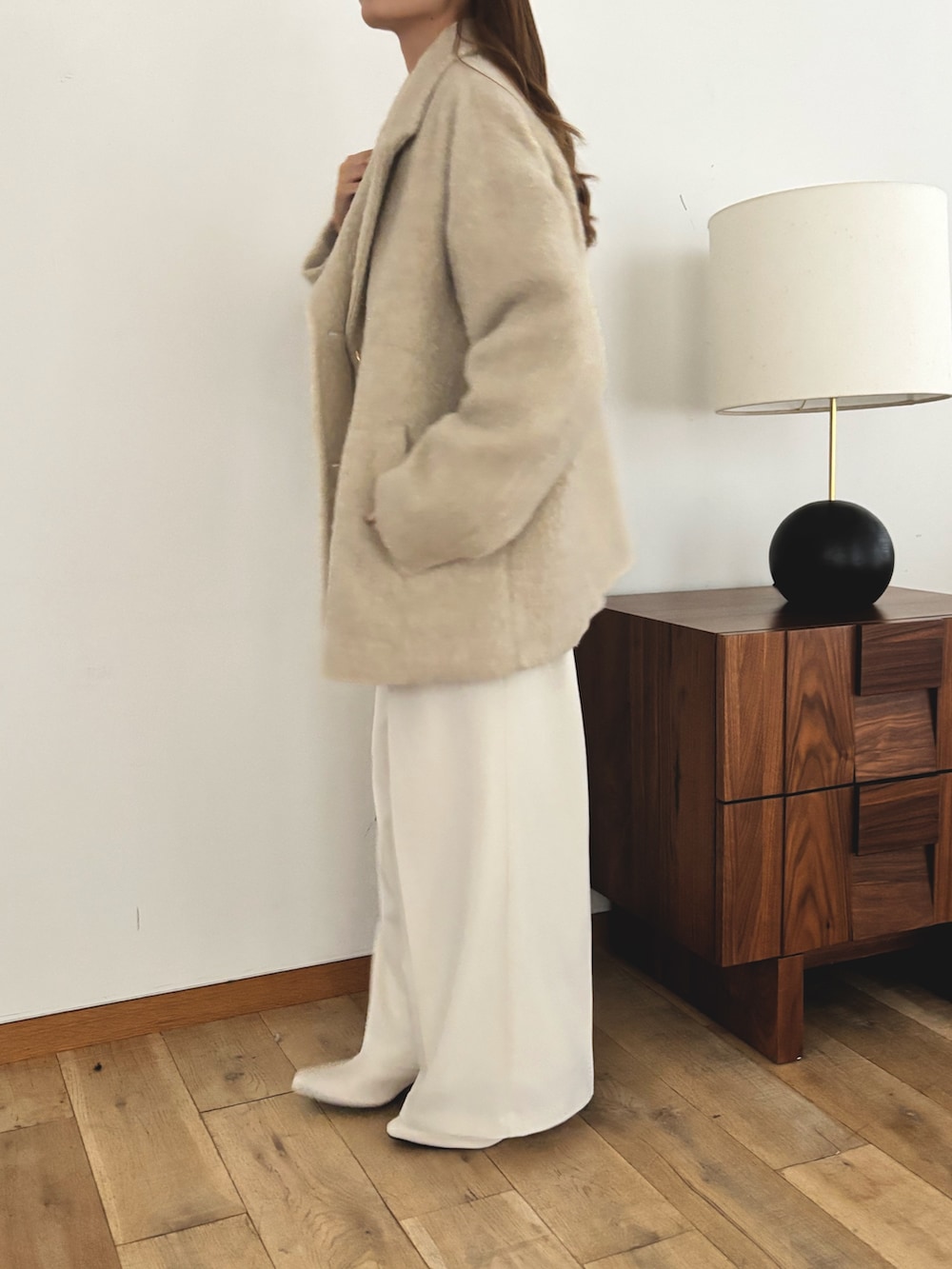 ベージュ系のピーコート、ホワイト系のスラックスを着用したレディースの秋コーディネートの4枚目の写真