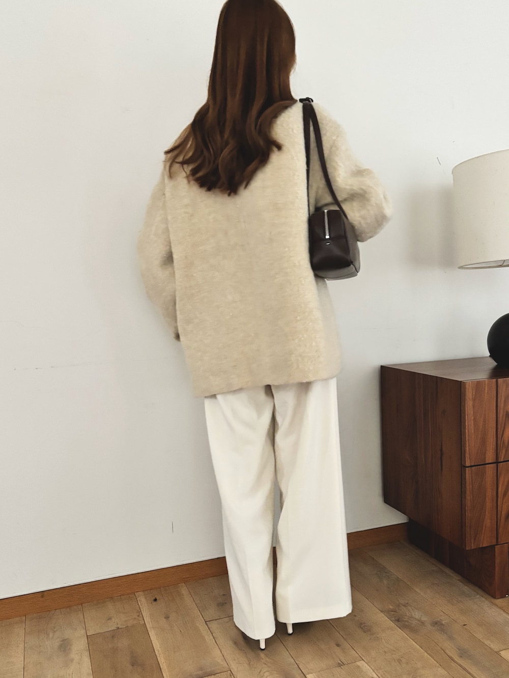 ベージュ系のピーコート、ホワイト系のスラックスを着用したレディースの秋コーディネートの5枚目の写真