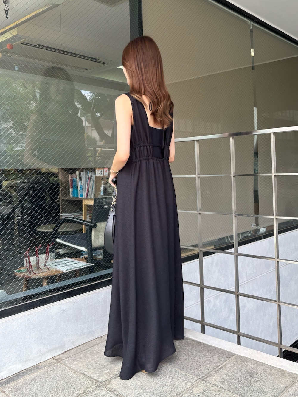 ブラック系のワンピースを着用したレディースの夏コーディネートの2枚目の写真