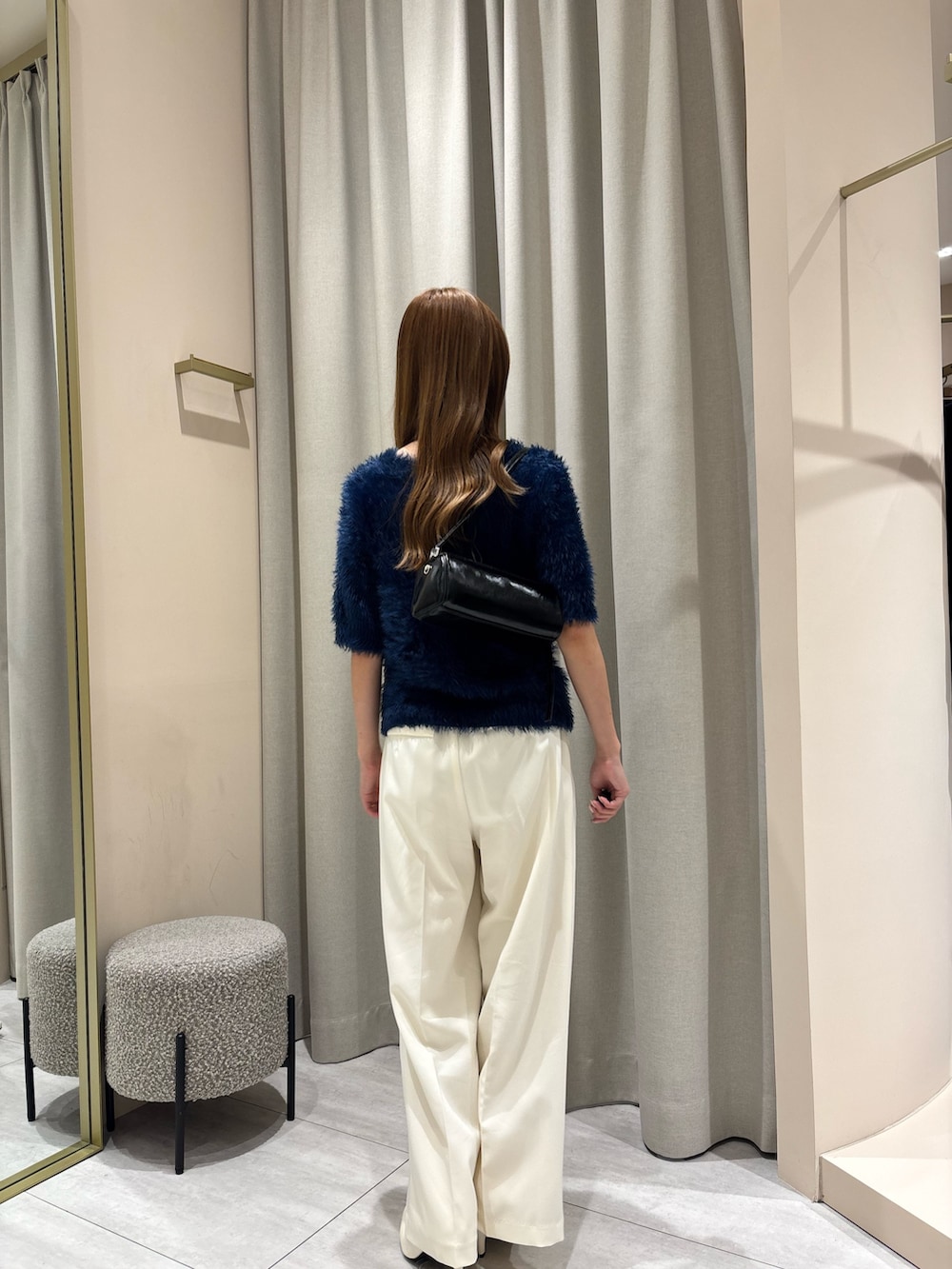 ブルー系のカーディガン/ボレロ、ホワイト系のスラックスを着用したレディースの秋コーディネートの3枚目の写真