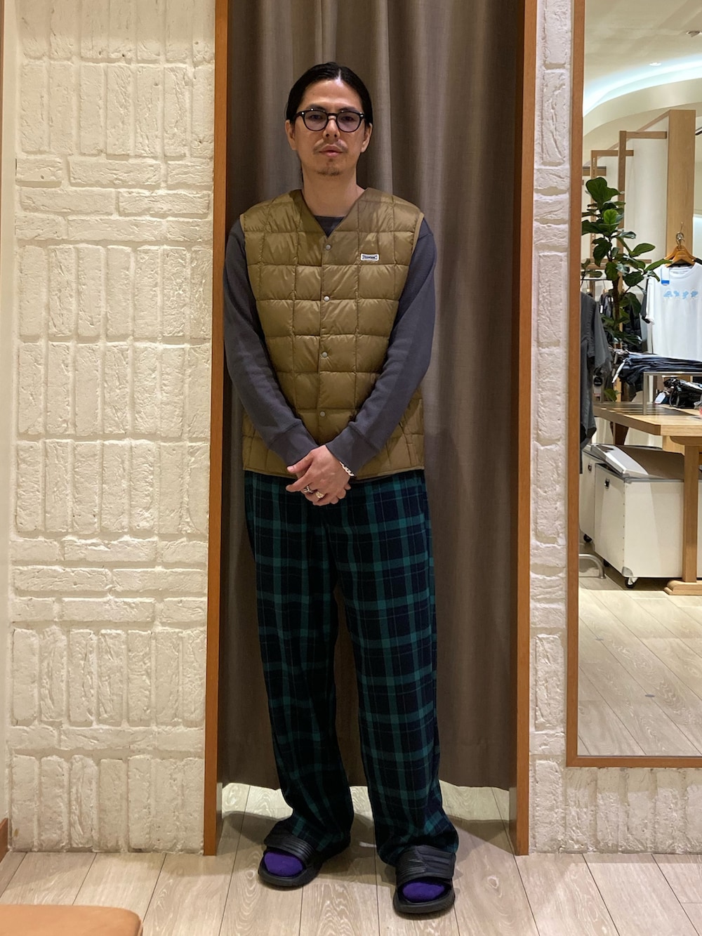 ベージュ系のダウンベスト、グレー系のTシャツ/カットソー、グリーン系のその他パンツを着用したメンズの秋コーディネートの4枚目の写真