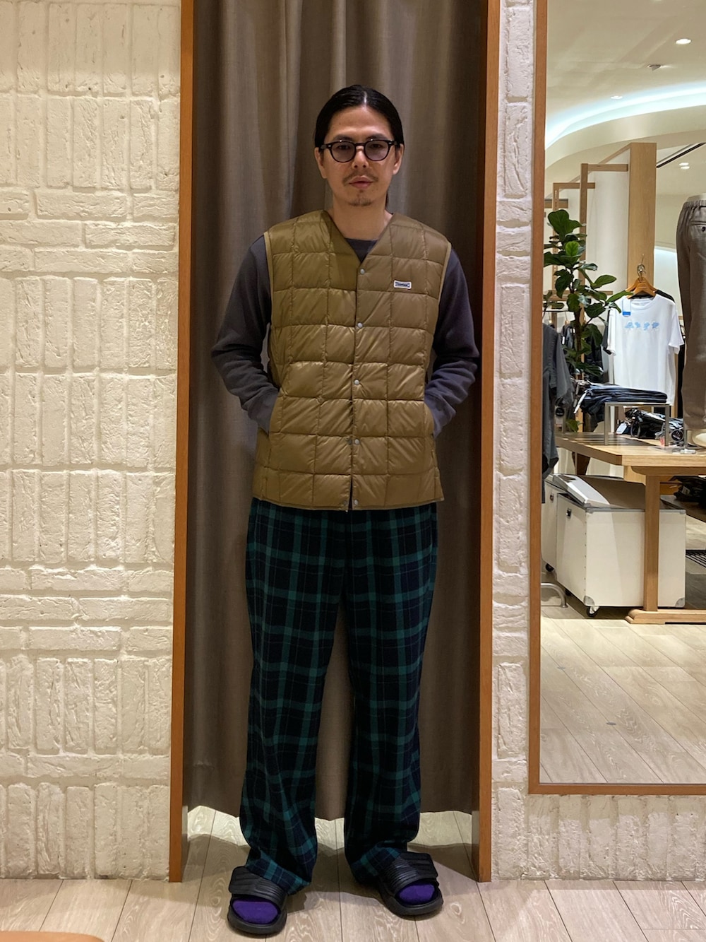 ベージュ系のダウンベスト、グレー系のTシャツ/カットソー、グリーン系のその他パンツを着用したメンズの秋コーディネートの2枚目の写真