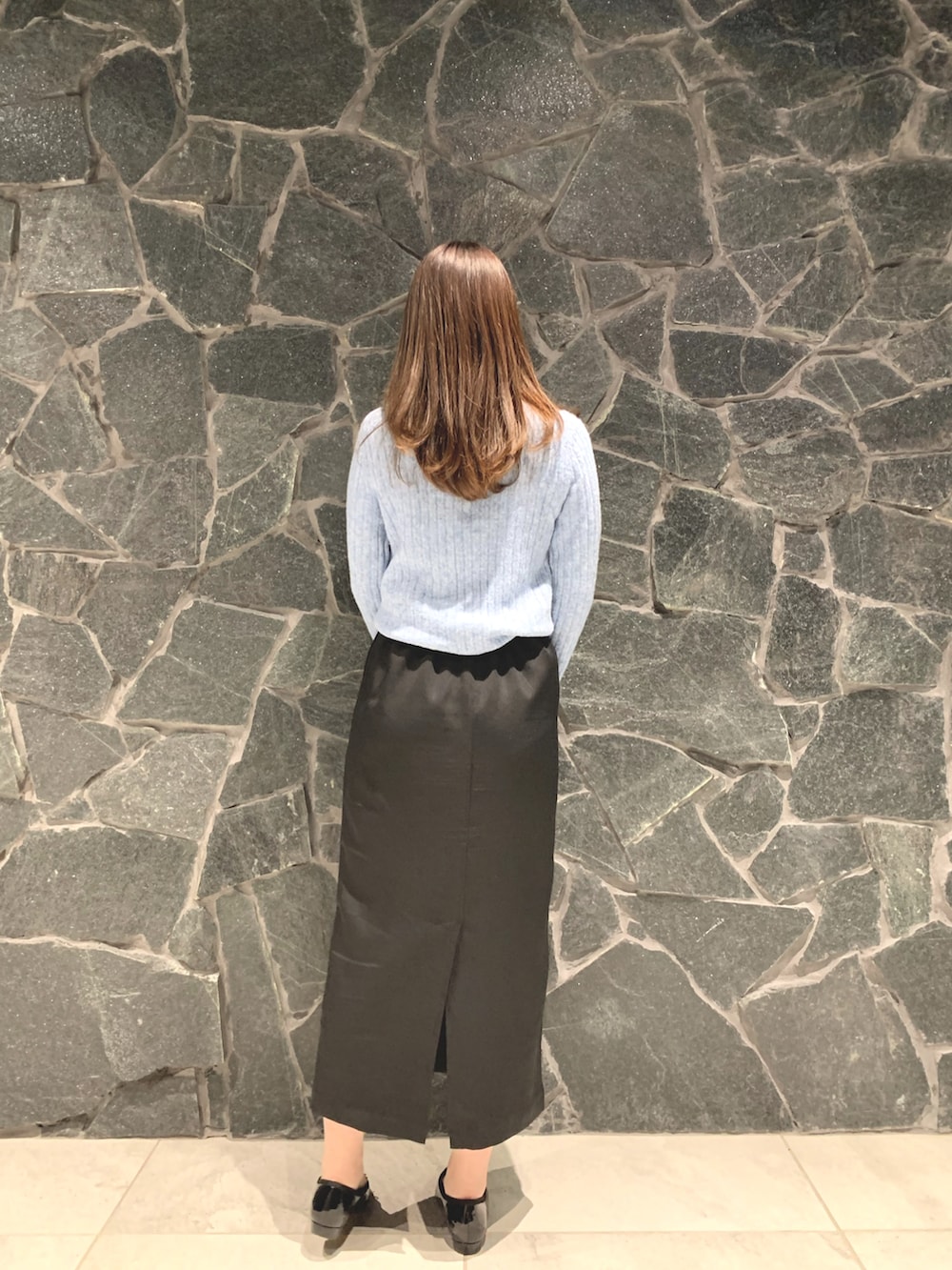 ブルー系のニット/セーター、ブラック系のハンドバッグ、ブラック系のスカートを着用したレディースの冬コーディネートの3枚目の写真