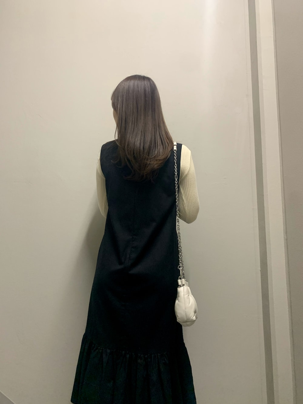 ブラック系のワンピース/ドレス、ベージュ系のニット/セーター、ホワイト系のバッグを着用したレディースの冬コーディネートの4枚目の写真