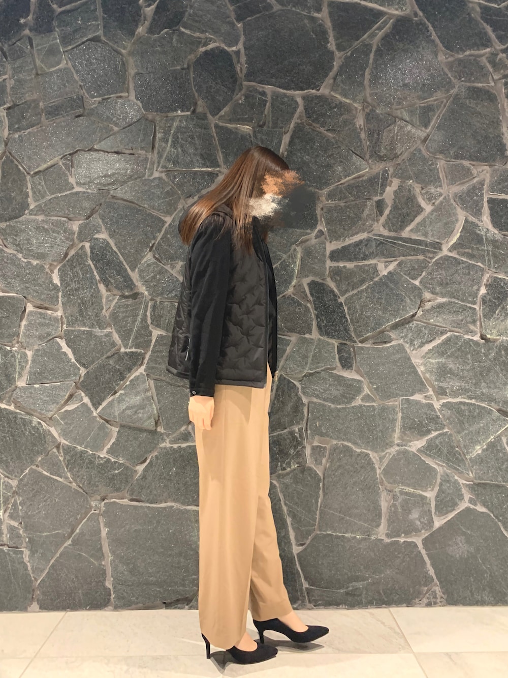 グレー系のパンツ、ブラック系のハンドバッグ、ブラック系のパンプスを着用したレディースの秋コーディネートの2枚目の写真