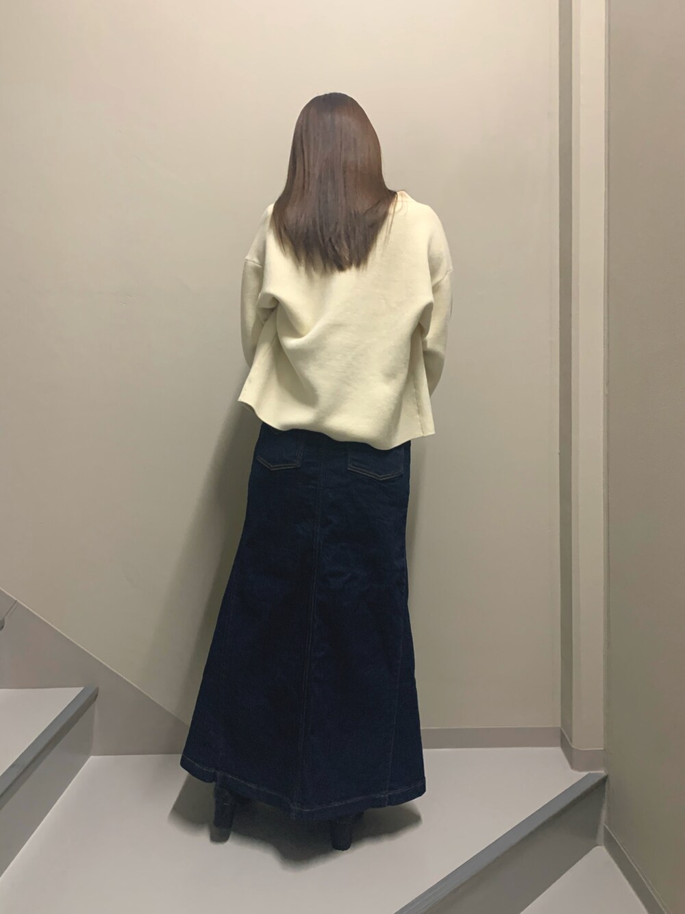 ホワイト系のカーディガン/ボレロ、ブラック系のニット/セーター、ブルー系のデニムスカートを着用したレディースの冬コーディネートの3枚目の写真