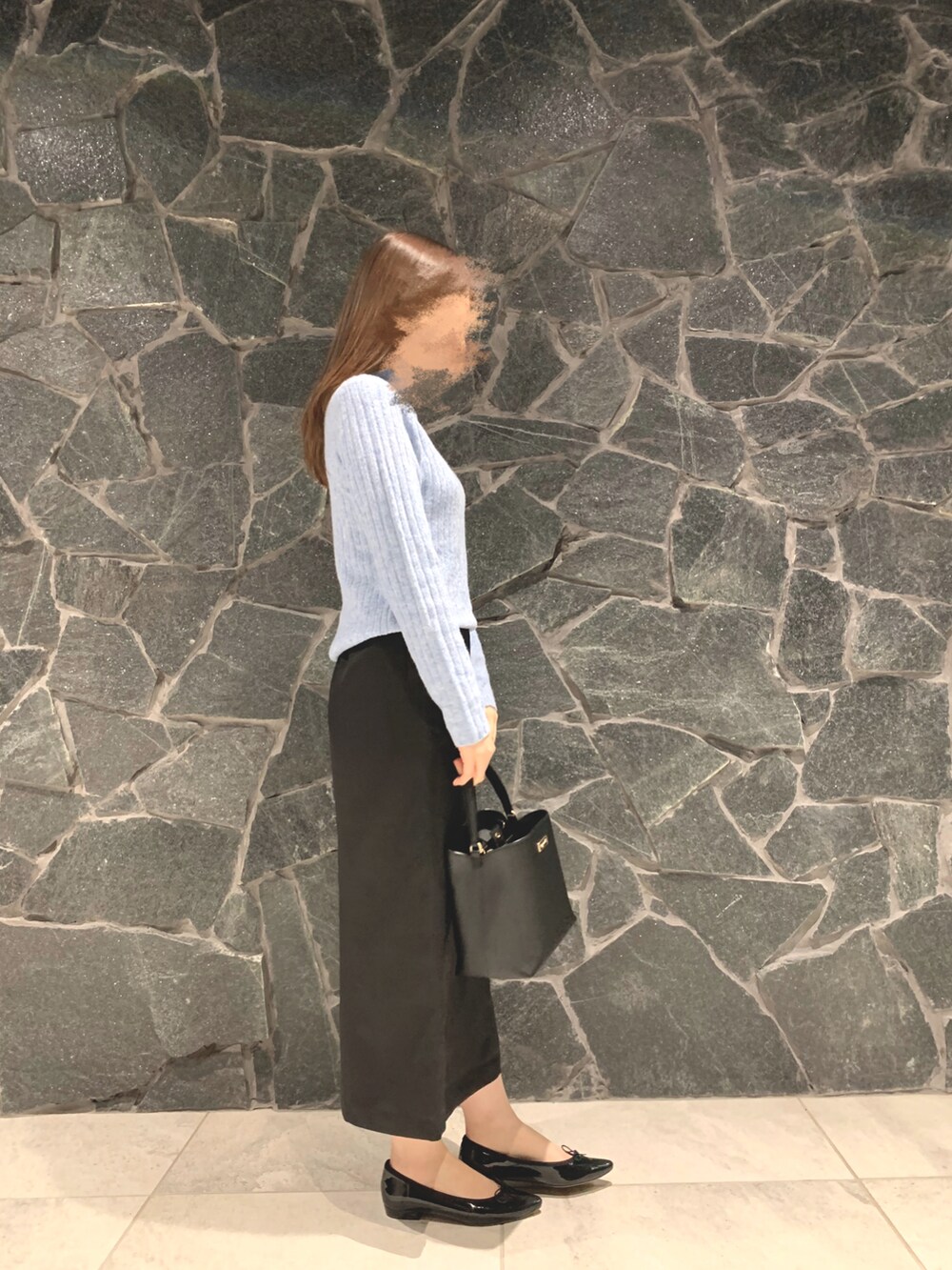 ブルー系のニット/セーター、ブラック系のハンドバッグ、ブラック系のスカートを着用したレディースの冬コーディネートの2枚目の写真