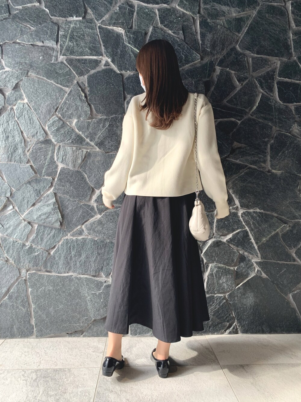 ホワイト系のカーディガン/ボレロ、ブラック系のバレエシューズ、ホワイト系のバッグを着用したレディースの冬コーディネートの3枚目の写真