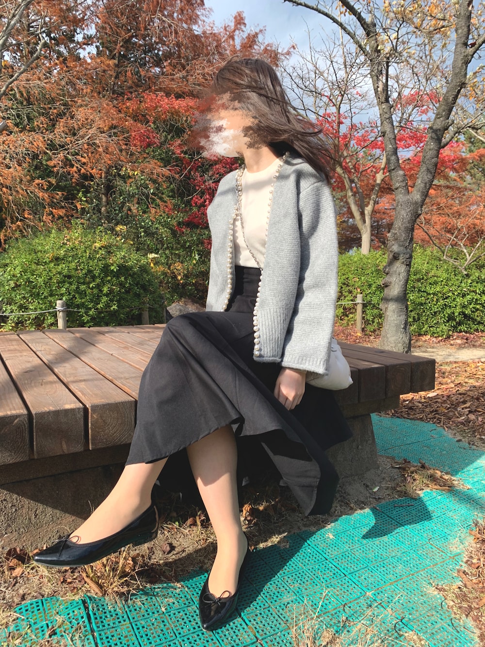 ホワイト系のニット/セーター、グレー系のジャケット/アウター、ブラック系のスカートを着用したレディースの秋コーディネートの3枚目の写真